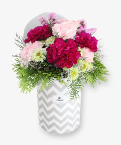 Elegant maroon and pink carnation arrangement in white hat box