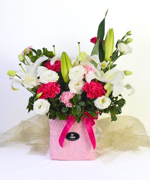 First-Class Mom flower basket with white lily, eustoma, pink carnations and tea leaves in Penan basket – Nurhampers